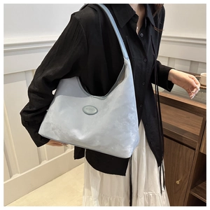 Close-up of light blue shoulder bag featuring premium cloud-textured fabric and logo detail