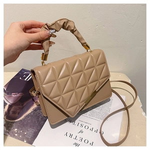 Détail du sac matelassé thé au lait avec motif triangulaire et poignée froncée