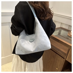 Detail of light blue hobo bag showing the moire texture and embossed logo