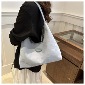 Detailed view of light blue suede shoulder bag shown with realistic lifestyle modeling
