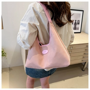 Close-up of the stylish pink hobo bag featuring a high-density nylon fabric and oval logo