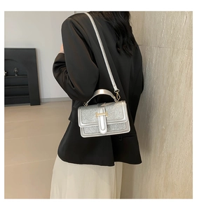 Detail of silver sequin bag featuring H-shaped gold buckle and detachable shoulder strap