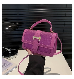 Close-up of purple sequin crossbody bag featuring a classic gold H metal buckle detail