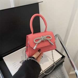 Sac à main rose avec nœud en strass et bandoulière en chaîne argentée
