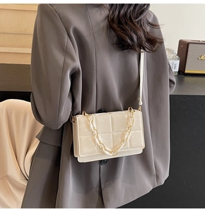 Détail sac bandoulière matelassé beige avec double chaîne sur mannequin en blazer