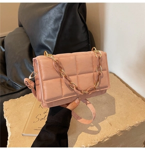 Detailed view of dusty pink quilted crossbody bag with large squares and matching chain strap