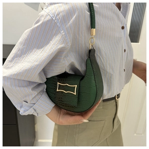 Close-up of a dark green embossed crescent shoulder bag with a gold H-shaped metal buckle