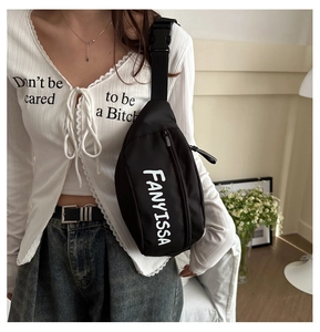 Detail of FANYISSA black nylon chest bag with white logo print and adjustable shoulder strap