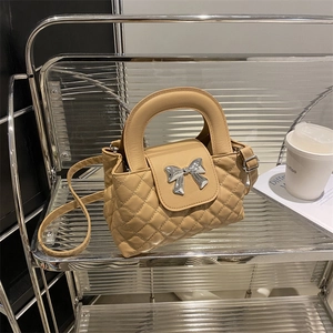 Khaki quilted crossbody bag with silver bow accent and adjustable shoulder strap
