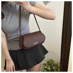 Mirror selfie showing the brown oval underarm bag size and fashion metal buckle detail