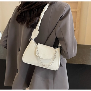 Détail du sac à bandoulière en cuir blanc avec chaîne florale et large sangle tressée