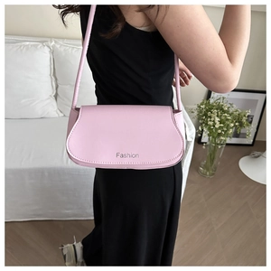 Close-up of pink faux leather shoulder bag featuring silver Fashion logo engraving