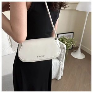 Elegant off-white rectangular shoulder bag with Fashion lettering shown on a model