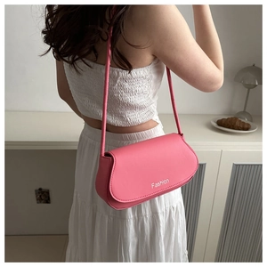 Close-up of a pink oval underarm bag with Fashion logo shown from a rear model view