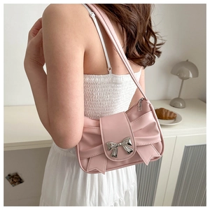 Detail of pink pleated shoulder bag featuring a decorative silver metallic bow buckle