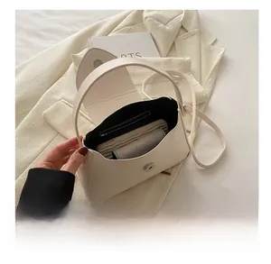 Internal capacity of the cream white crossbody bag showing storage for phone and power bank