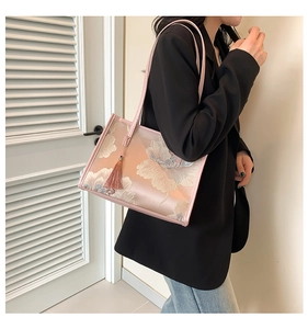 Borsa tote in seta rosa con ricami floreali e nappina decorativa portata a spalla