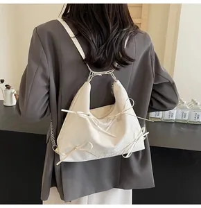 Détails du sac hobo beige avec nœuds élégants et fines bandoulières réglables