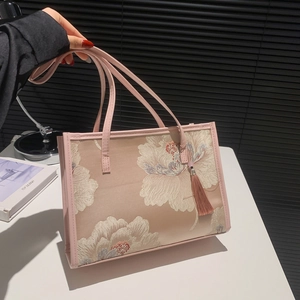 Pink satin tote bag with floral embroidery and tassel detail in elegant Chinese style