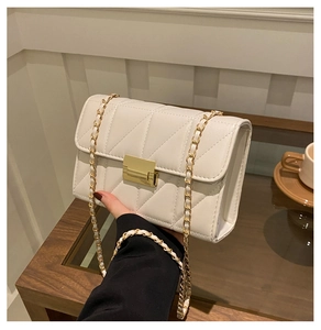 Détail du sac bandoulière matelassé crème avec fermoir doré et bandoulière chaîne