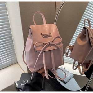 Detail of pink PU leather backpack with drawstring closure and decorative bow ornament