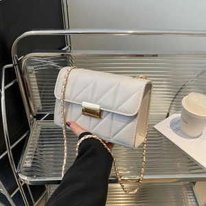 Sac bandoulière crème matelassé avec fermoir doré sur fond design minimaliste chic