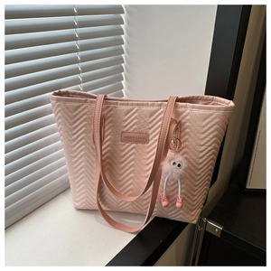 Dettaglio borsa tote rosa trapuntata con cuciture a V e ciondolo in pelliccia