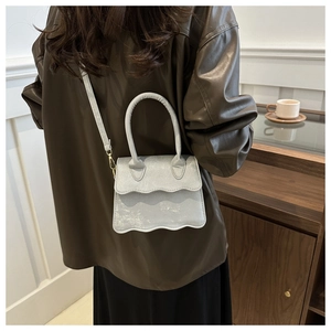 Detailed back view of a chic silver crossbody bag with unique wavy edges and metallic finish