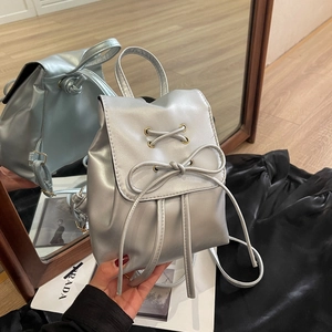 Mini mochila plateada para mujer con lazo elegante y acabado de cuero sintético brillante