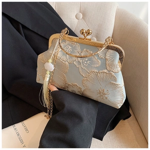 Close-up of vintage blue silk handbag with gold floral embroidery and metallic handle