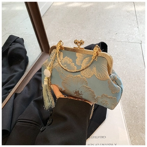 Close-up of vintage blue floral jacquard evening bag with golden metal kiss lock clasp