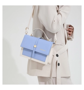 Détail du sac à main bicolore bleu clair avec boucle dorée et bandoulière réglable