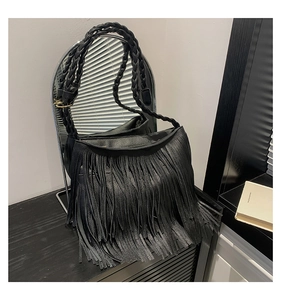 Close-up of black tassel crossbody bag with braided shoulder strap and gold hardware