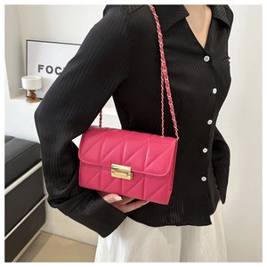 Pink quilted shoulder bag with V-shaped stitching and gold chain strap on model