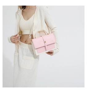 Détail du sac bandoulière rose et beige avec boucle ronde en métal et sangle réglable