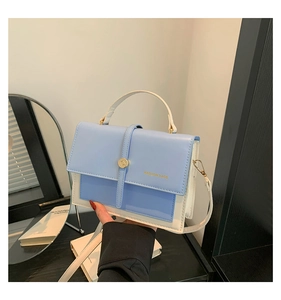 Détail du sac à main bicolore bleu clair et blanc avec fermoir doré et poignée