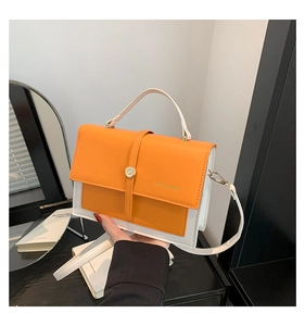 Détail d'un sac à main bicolore orange et blanc avec fermoir en métal et bandoulière