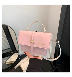 Détail du sac à main bicolore rose et blanc avec boucle dorée et bandoulière amovible