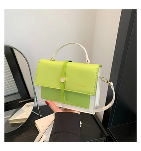 Détail d'un sac bandoulière vert et beige avec boucle métallique et poignée supérieure