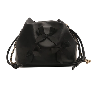 Sac seau en cuir PU noir avec nœuds en ruban et bandoulière en chaîne dorée, vue de face
