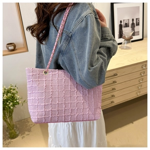Detailed shot of pink waffle texture tote bag with gold chain strap worn by a model