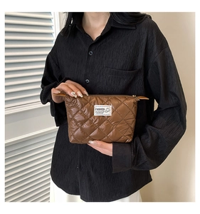 Détail de la pochette matelassée marron foncé avec étiquette en tissu fashion