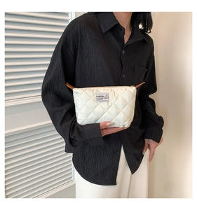 Détail d'une pochette matelassée avec zip doré et étiquette de marque élégante