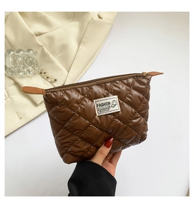 Gros plan d'une pochette marron matelassée avec étiquette tendance et motif losanges
