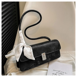 Detail of a vintage black rectangular shoulder bag with a diamond buckle and silk scarf
