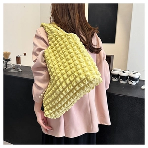 Detail of light yellow cloud bubble textured shoulder bag with popcorn pleat fabric design