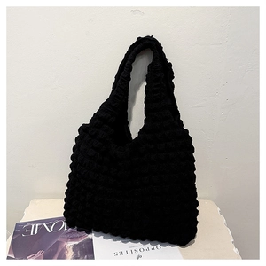Detail of black pleated tote bag showing 3D bubble texture and cloud-like fabric