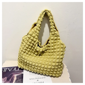 Detail of mustard yellow bubble textured shoulder bag with soft pleated fabric surface