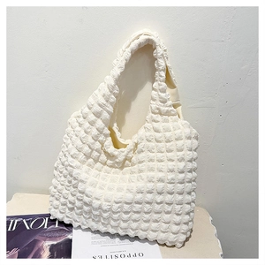 Detail of white popcorn texture shoulder bag showing unique 3D puffed fabric and soft strap