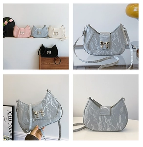 Detail view of metallic pleated crescent bags in pink, blue, cream, black and silver colors